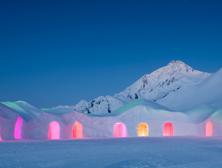 Snow hills with houses in them and colourful doors