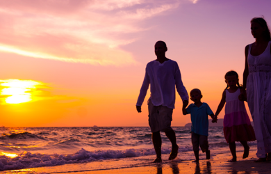 Family on the beach at sunset