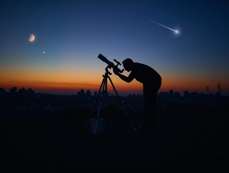 Through A Telescope Lens At Nigh With Stars And A Moon In The Background